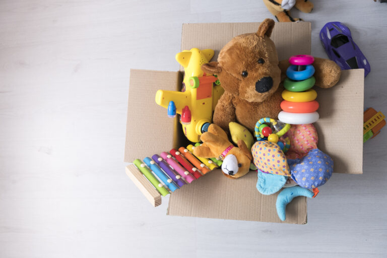 box of toys on the floor. Teddy bear in box,vintage tone. charitable contribution. donation. beneficence.